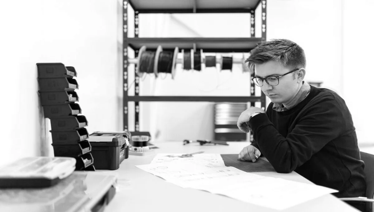 Un jeune ingénieur conseil étudaint un projet dans son bureau