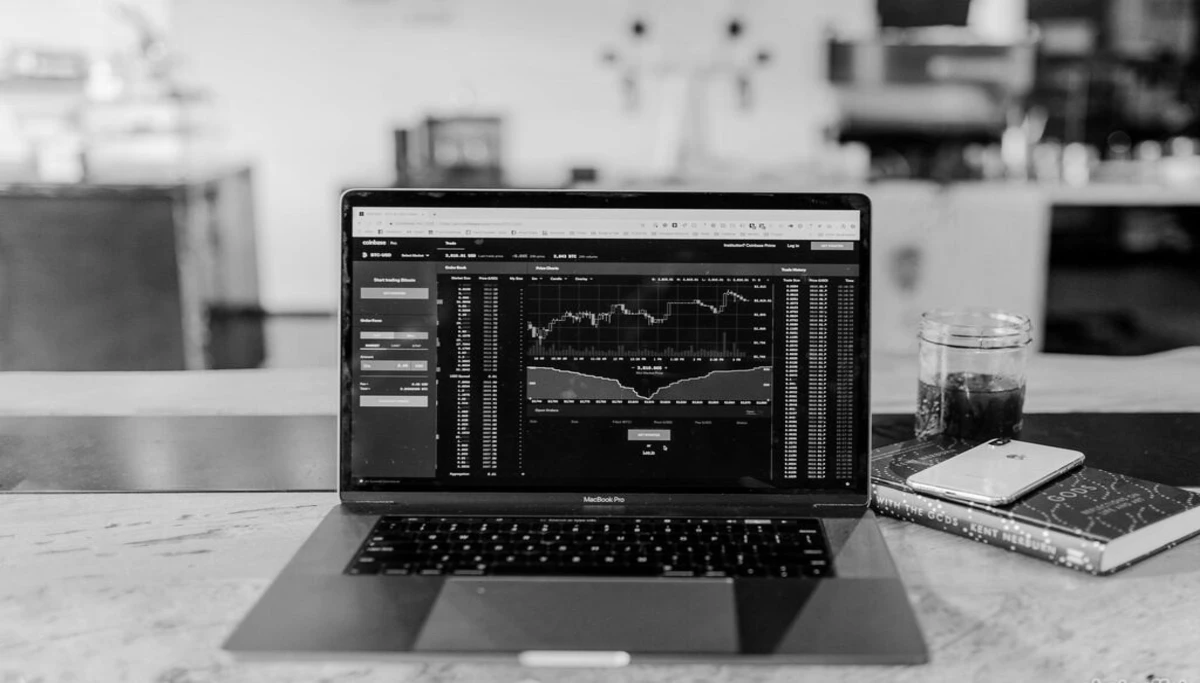 Un PC affichant des métriques un téléphone et une bloc note sur une table